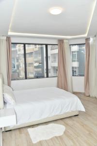 BRAND NEW! 3 Bedroom Apartment in the Heart of Kenitra في القنيطرة: سرير أبيض في غرفة مع نافذة كبيرة
