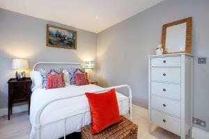 a bedroom with a white bed with red pillows at Veeve - Sunshine Joy in London