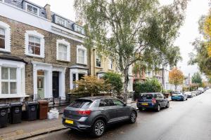 two cars parked on a street in front of buildings at Veeve - Sunshine Joy in London