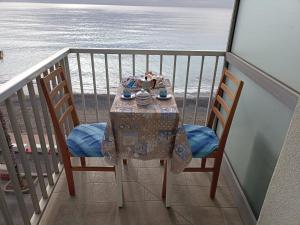 a table on a balcony with a view of the ocean at Appartamento ITACA - CITRA 08065-LT-0722 in Ventimiglia