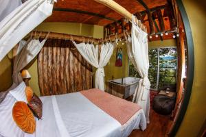 ein Schlafzimmer mit einem Himmelbett und einem Fenster in der Unterkunft ANCESTRAL GLAMPING in Barbosa