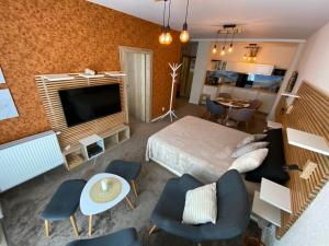 a room with a bed and a television and a living room at Apartmány Impresia - Bernard in Vysoké Tatry
