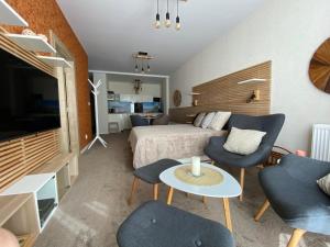 a bedroom with a bed and chairs and a tv at Apartmány Impresia - Bernard in Vysoké Tatry
