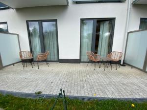 a group of chairs sitting in front of a building at Apartmány Impresia - Bernard in Vysoké Tatry