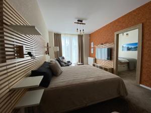 a hotel room with a bed and a television at Apartmány Impresia - Bernard in Vysoké Tatry