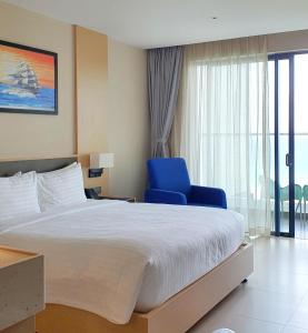um quarto com uma cama grande e uma cadeira azul em Seaview Cam Ranh Beach Resort Nha Trang Near The Airport Best Location em Cam Ranh