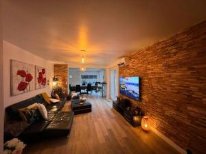 a living room with a large brick wall at Maison entière Redessan in Redessan