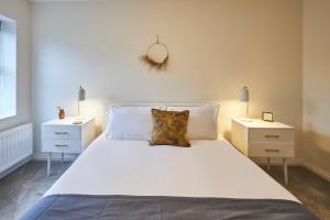 a bedroom with a large white bed with two night stands at Host & Stay - Studio No.8 in Alnwick