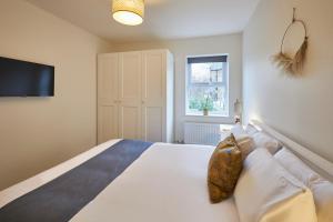 Un dormitorio con una gran cama blanca y una ventana. en Host & Stay - Studio No.8, en Alnwick