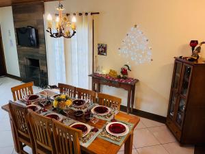 a dining room with a table and a christmas tree at Casa para Descanso in Campos do Jordão