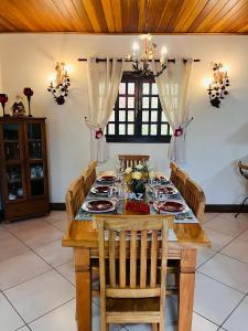 een eetkamer met een houten tafel en stoelen bij Casa para Descanso in Campos do Jordão
