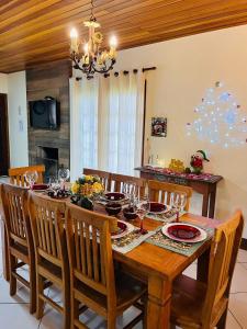 comedor con mesa de madera y sillas en Casa para Descanso, en Campos do Jordão