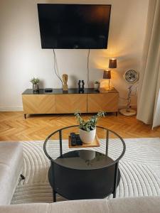 ein Wohnzimmer mit einem Tisch und einem Flachbild-TV in der Unterkunft Exklusives Apartment im Herzen Saarbrückens in Saarbrücken