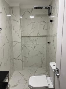 a bathroom with a toilet and a stone wall at Casa de praia in Camboriú