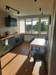 a kitchen with a table and chairs in a room at Fukša Saules dzīvoklis in Madona