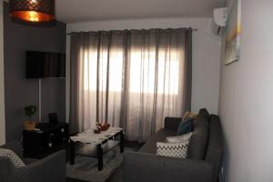 - un salon avec un canapé et une fenêtre dans l'établissement Appartement Pinheiro, à Portimão
