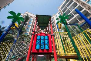 dos personas en un parque infantil en un complejo en Atlantis Condo Resort Pattaya, en Jomtien Beach