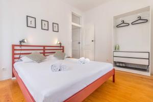 a bedroom with a large white bed with towels on it at São Vicente @ Heart of Alfama in Lisbon