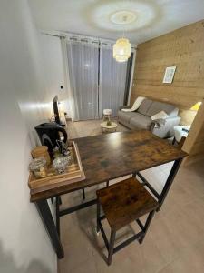- un salon avec une table en bois et un canapé dans l'établissement Studio cosy vallée de Tarentaise, à Aime La Plagne
