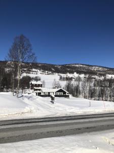 a person riding a snowboard down a snow covered road at Stugu - Koselig hytte med sentral beliggenhet 