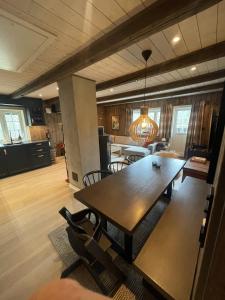 a dining room and kitchen with a wooden table and chairs at Stugu - Koselig hytte med sentral beliggenhet in Åker