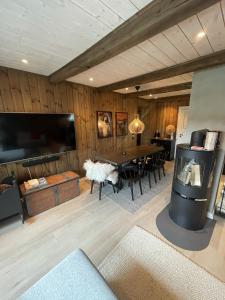 a living room with a table and a tv at Stugu - Koselig hytte med sentral beliggenhet 