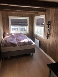 a bedroom with a bed and two windows at Stugu - Koselig hytte med sentral beliggenhet in Åker +24 photos
