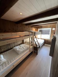 a room with two bunk beds in a cabin at Stugu - Koselig hytte med sentral beliggenhet 