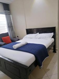 a bedroom with two beds and a chair at B&S Studio apartment, Voi Town in Voi