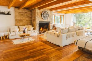 uma sala de estar com sofás brancos e uma lareira em Hosteria Boutique Bariloche em San Carlos de Bariloche