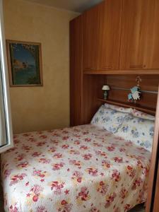 a bedroom with a bed with a floral bedspread at Appartamento ITACA - CITRA 08065-LT-0722 in Ventimiglia