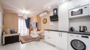 Apartamento a 3 min de la playa في توريفايجا: مطبخ مع غسالة ملابس وغرفة معيشة