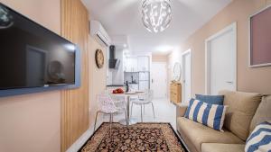 Apartamento a 3 min de la playa في توريفايجا: غرفة معيشة مع أريكة وطاولة مع كراسي