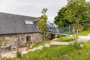 an external view of a stone house with a walkway at Edinbane Self Catering - On the Croft at Edinbane in Edinbane