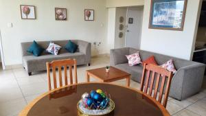 a living room with a couch and a table and chairs at Upmarket Beach Flat, Free WiFi & DisneyPlus in Durban