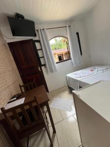 a small room with a bed and a window at Pesque pague pousada do Carlinho in Pinheiral