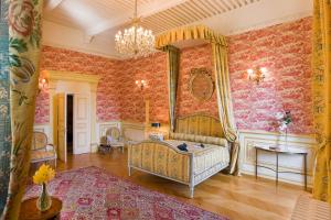 een slaapkamer met een bed in een kamer met behang bij Chateau De Picomtal in Crots