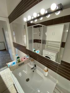 un lavandino in bagno con specchio e lavatrice di CASA BALU' a Roma