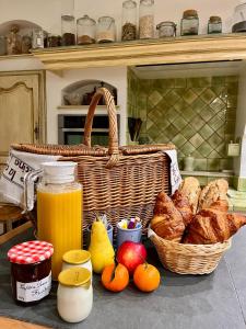 a table with a basket of bread and a basket of fruit at L'Oliveraie de Paul in Aigues-Mortes