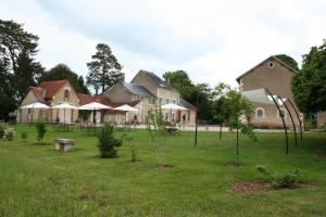 una casa con un patio con árboles delante de ella en Domaine du Bouloy, en Druyes-les-Belles-Fontaines