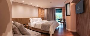 um quarto de hotel com uma cama e uma televisão em Village Du Lac Hotel em Pomerode