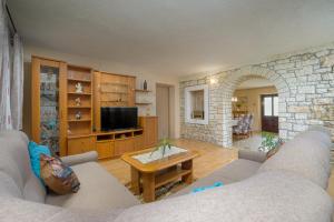 salon z 2 kanapami i kamienną ścianą w obiekcie Holiday Apartment Ariella w mieście Križanici