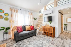 a living room with a couch and a television at 5 Cozy Casita Lux Tiny House, Firepit, 5 Mins To Downtown Guntersville in Guntersville