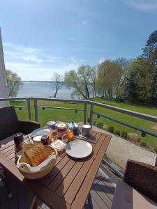 einen Tisch mit Nahrung und Blick auf das Wasser in der Unterkunft Fewo am Plöner See in Ascheberg