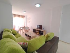 - un salon avec un canapé vert et une table dans l'établissement ACV - Bahia Park-1ª linea planta 2 frontal, à Oropesa del Mar