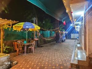 a table with an umbrella on a street at night at Chandraprabha Nyahari Niwas in Malvan