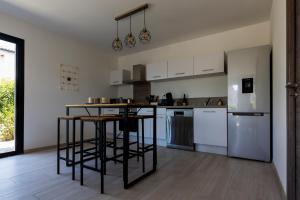 a kitchen with white cabinets and a black counter top at Villa MAYA in Lecci +3 photos
