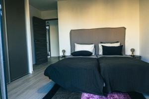 a bedroom with a large bed with black sheets and pillows at Villa MAYA in Lecci