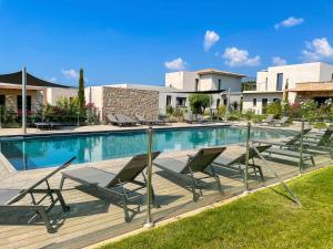 a swimming pool with lounge chairs next to a building at Villa MAYA in Lecci