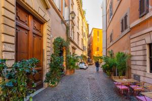 una persona caminando por una calle en un callejón en Central Charm near Piazza Navona - Cozy Loft for 2, en Roma